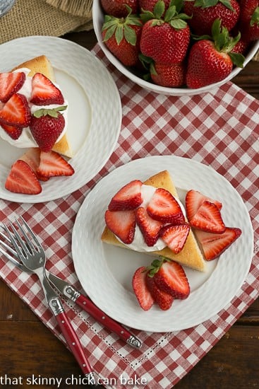 Slices of Visitidine Cake topped with berries and whipped cream viewed from above