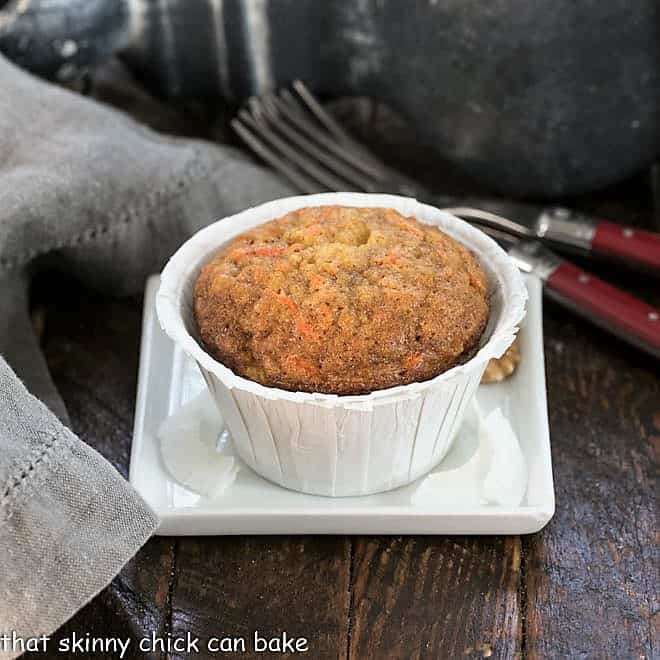 one carrot cake muffin on a small squarae white plate