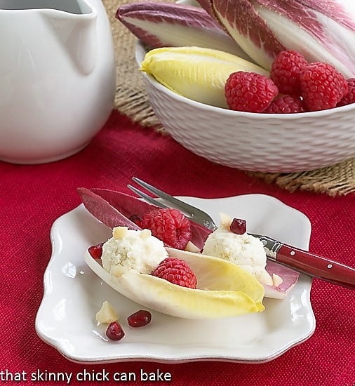 Endive Cups with Blue Cheese, Raspberries and Macadamia Nuts on a white plate