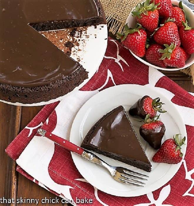 Flourless Double Chocolate Cake slice from above on a white plate with a red handled fork