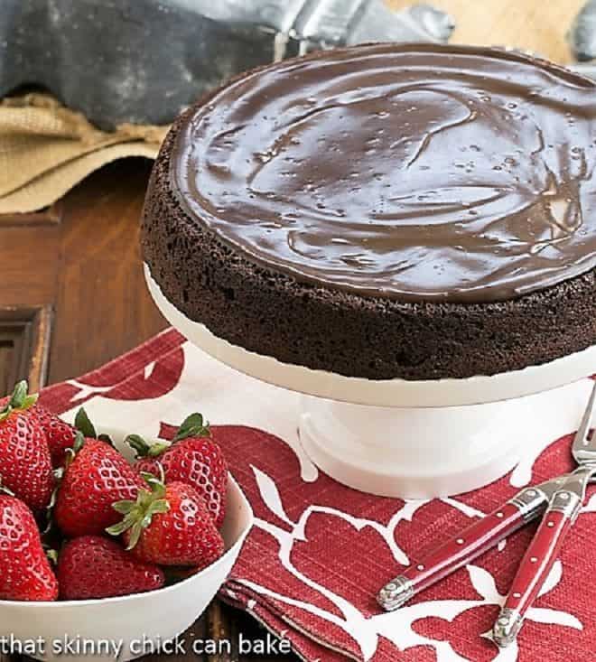 Flourless Double Chocolate Cake on a white ceramic cake stand