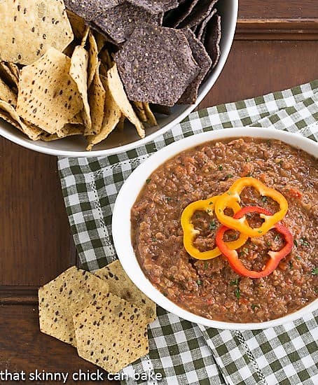 Smoky Black Bean Dip in a white bowl with a bowl of tortilla chips.