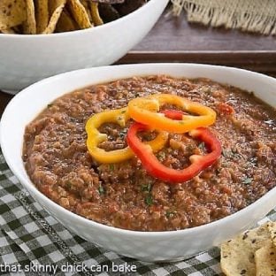 Smoky Black Bean Dip in a white bowl topped with fresh bell pepper rings