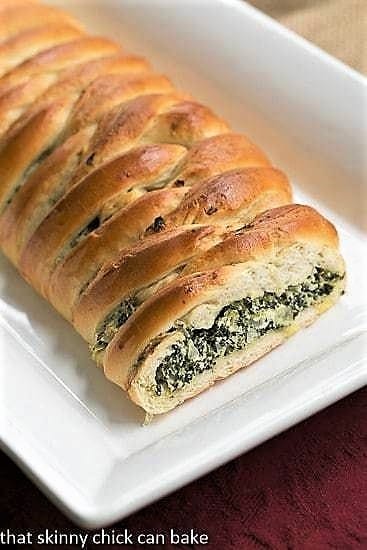 Spinach and Onion Braid on a long white platter with the filling exposed.