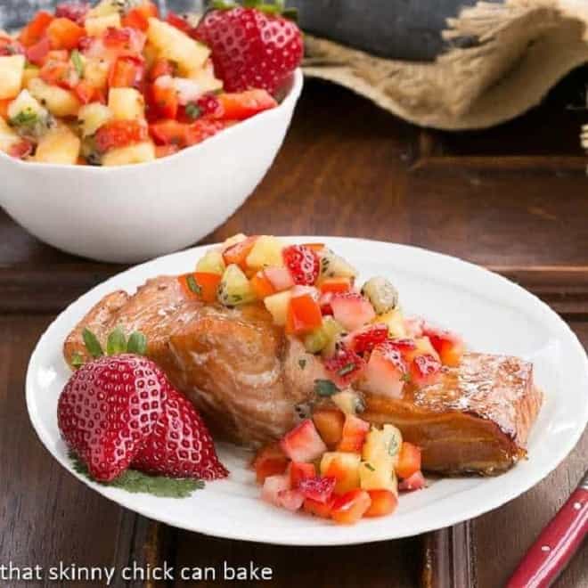 Strawberry Salsa Topped Salmon garnished with fresh strawberries on a white plate