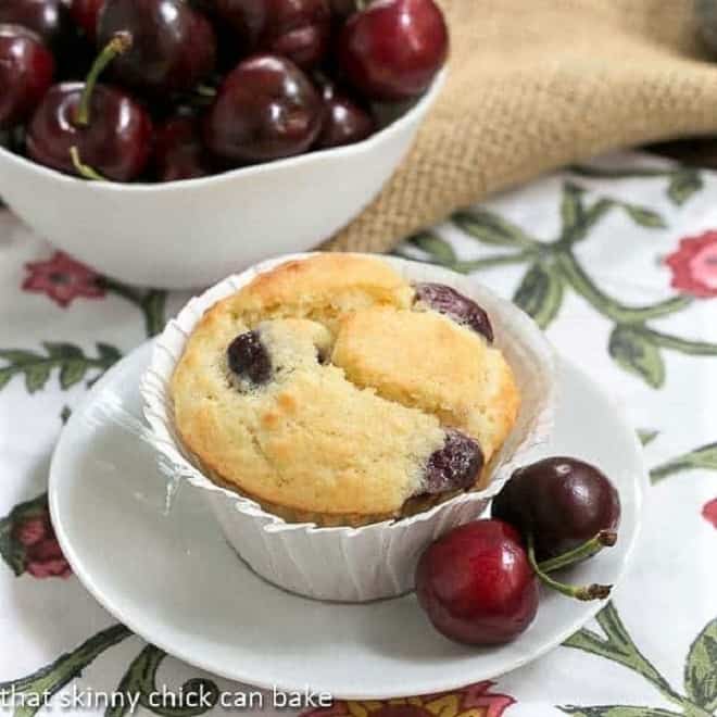 Double Cherry Muffins on a white plate with fresh cherries
