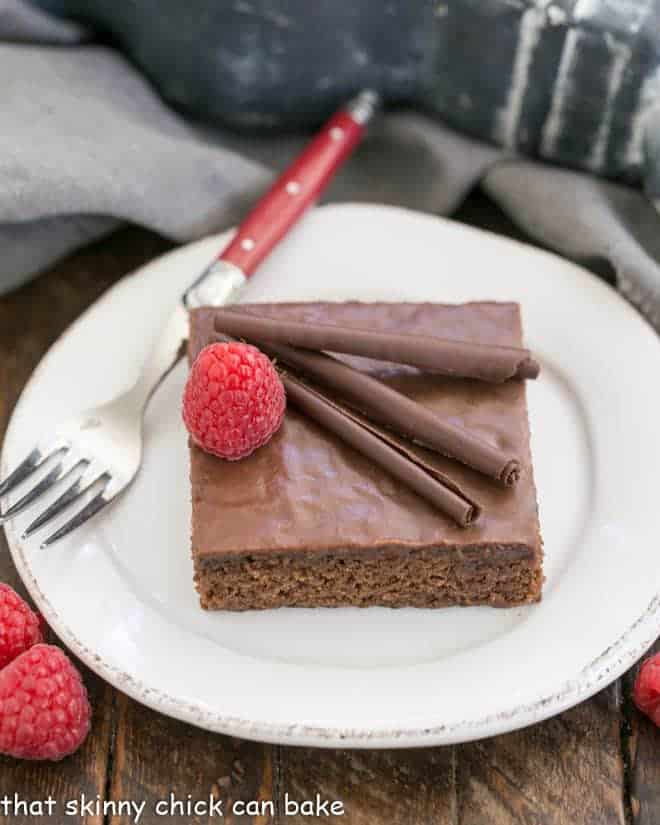 Chocolate Syrup Brownies topped with chocolate curls and a raspberry.