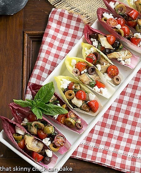 A tray of endive boats on a red and white checked napkin.