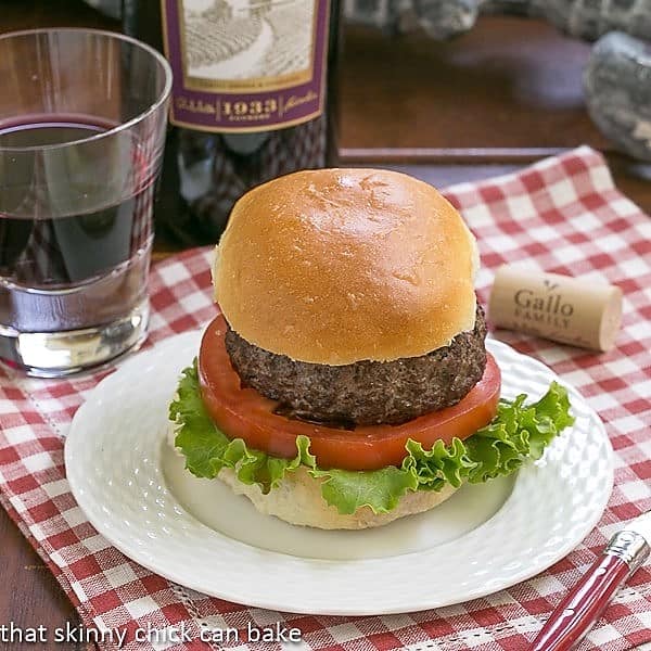 California burger on a white plate over a checked napkin