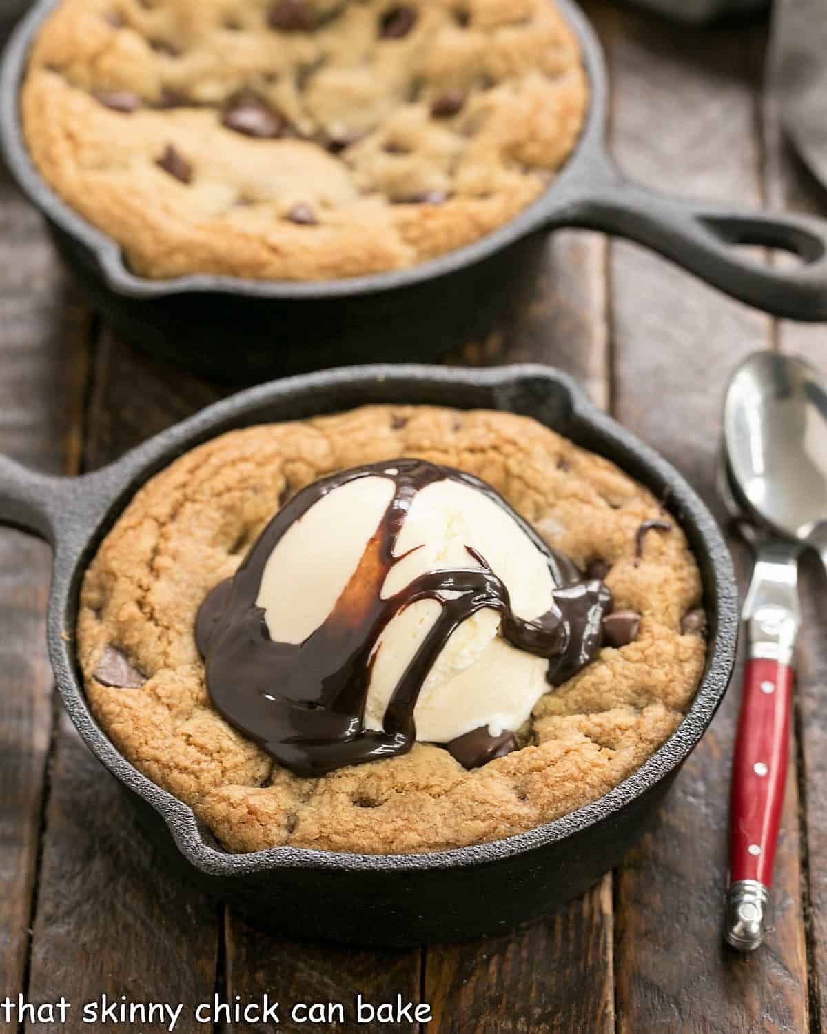 Big pizza cookiesa cast iron skillets with one topped with ice cream.