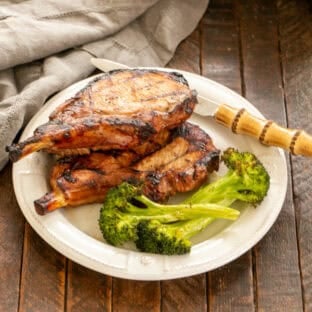 Marinated pork chops with broccoli on a dinner plate.