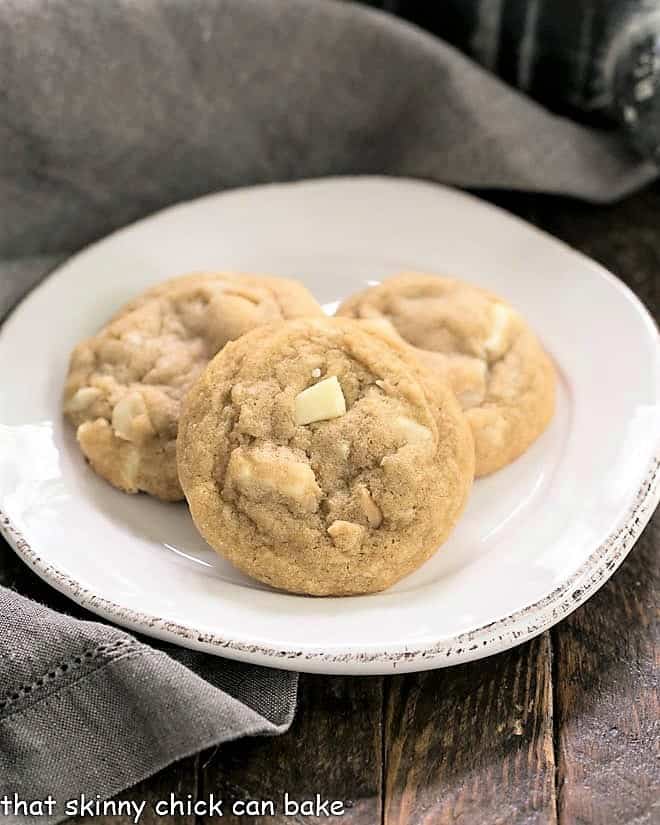 3 white chocolate macadamia nut cookies on a white plate