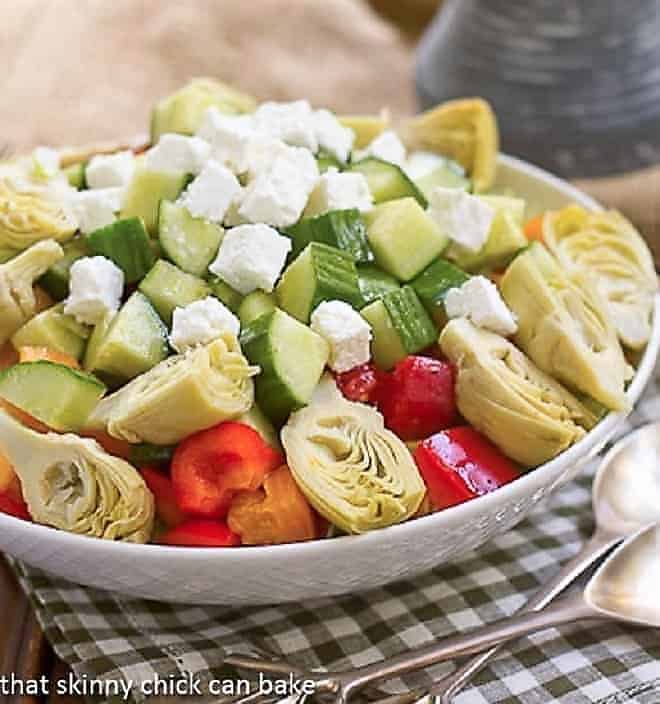 A white bowl of Greek Salad topped with feta cubes