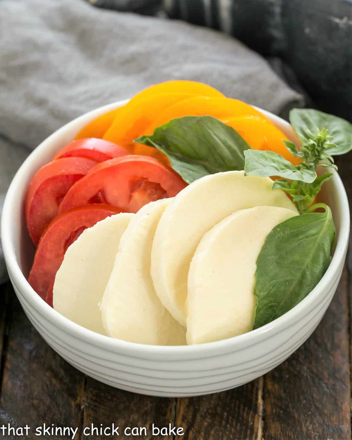 Homemade Pizza Margherita toppings sliced in a white bowl.