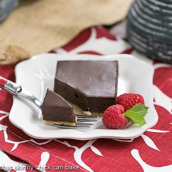 Truffle Brownies on a white plate with a fork removing a bite.