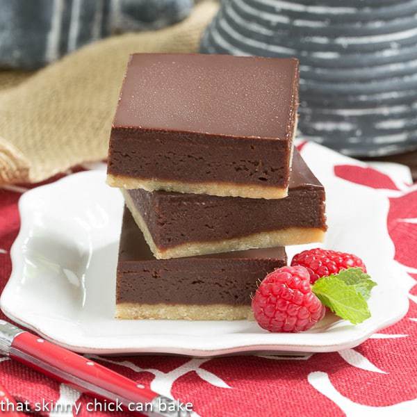 Truffle Brownies stacked on a white square plate.