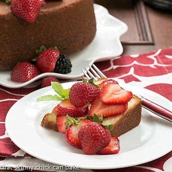 Slice of Vanilla Pound Cake on a white dessert plate topped with berries.