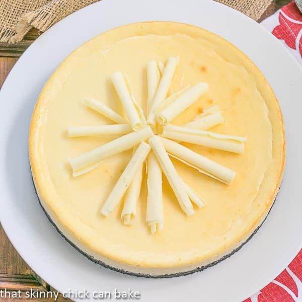 White Chocolate Frangelico Cheesecake on a white plate topped with white chocolate curls