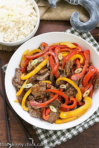 Overhead view of Asian Stir Fry Beef in a white bowl over a checkered napkin