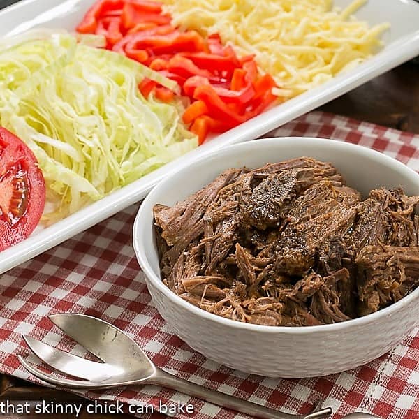 Slow Cooker Beef Barbacoa in a white bowl with toppings