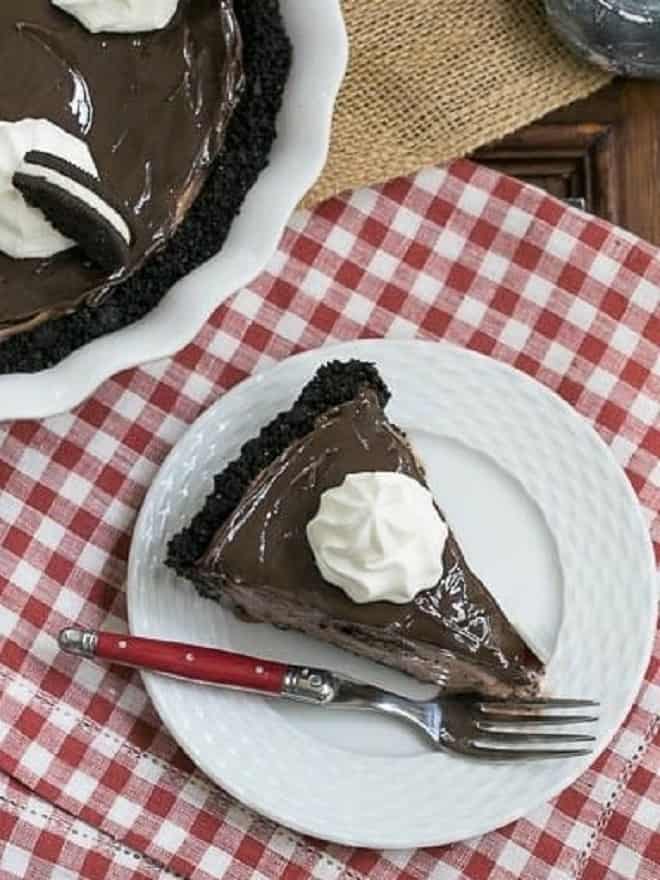 Slice of Fudge Topped Chocolate Ice Cream Pie on a white dessert plate