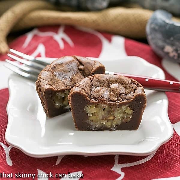 German Chocolate Brownie Cupcakes cut in half on a white dessert plate with a red handled fork.