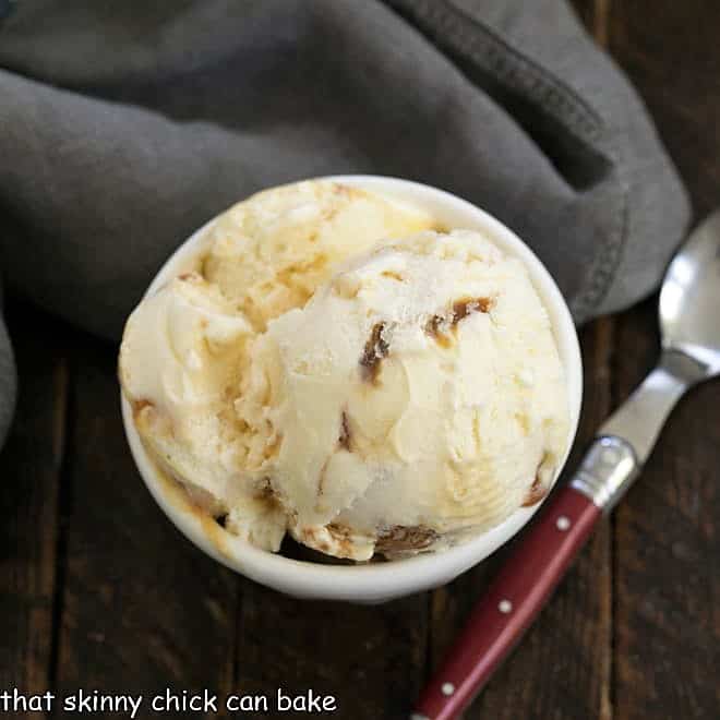 bowl of caramel swirl ice cream with a red handled spoon