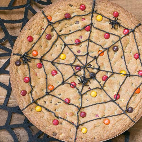 Spiderweb Cookie Cake topped with M&M's on a felt spiderweb.