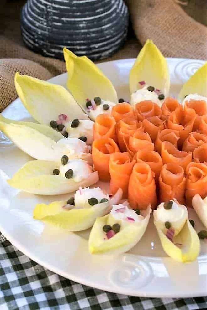 Smoked salmon roses- arranged on a white serving plate with endive, creme fraiche, capers and red onion