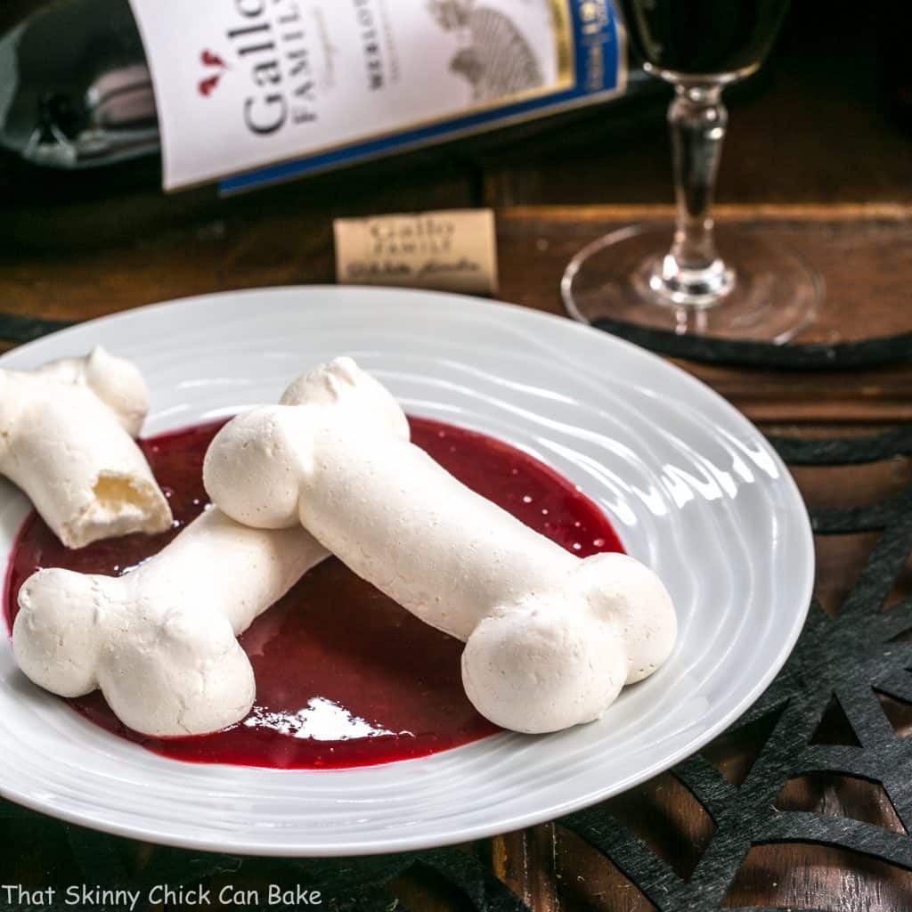 Meringue Bones on a white plate with a bottle of wine