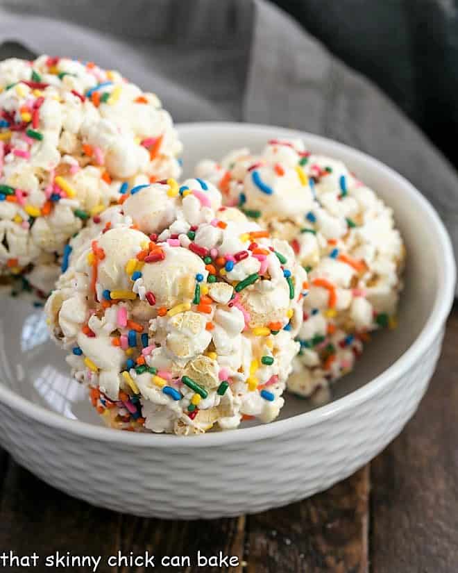 3 Easy Marshmallow Popcorn Balls in a white bowl.