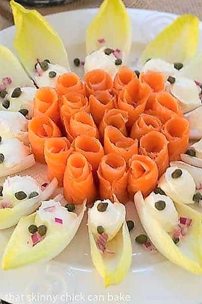 Close view of Smoked Salmon Roses with Endive and Creme Fraiche on a smoked salmon plater