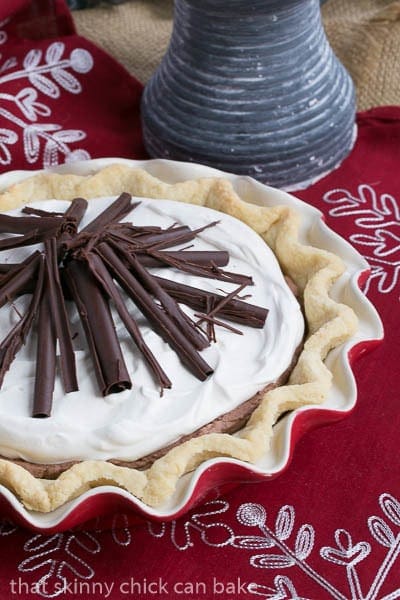 Uncut Black Bottom Chocolate Mousse Pie in a red pie plate with chocolate curl garnishes