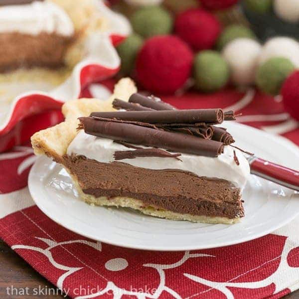 Slice of chocolate mousse pie on a white plate over a red and white napkin