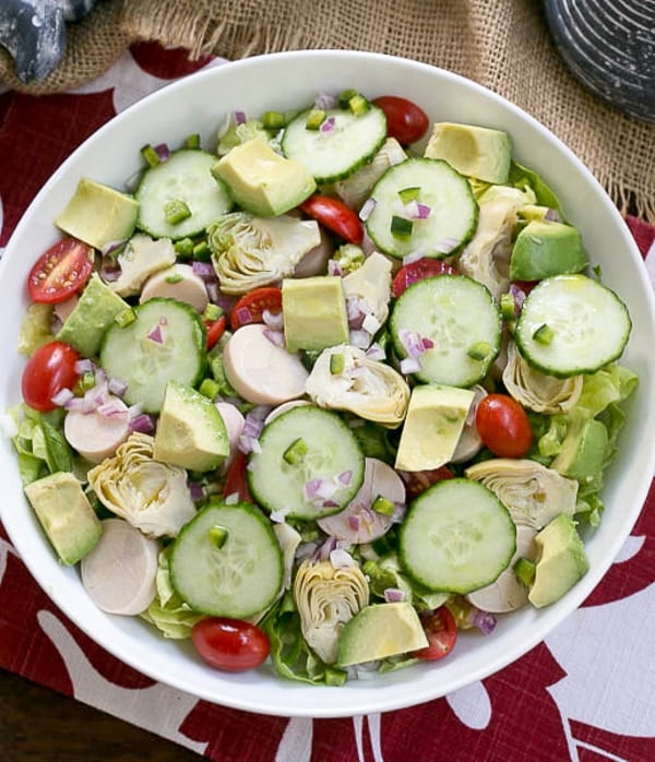 Hearts of Palm, Artichoke, Avocado and Butter Lettuce Salad overhead view in a serving bowl.