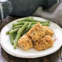 homemade chicken nuggets on a white plate with roasted green beans
