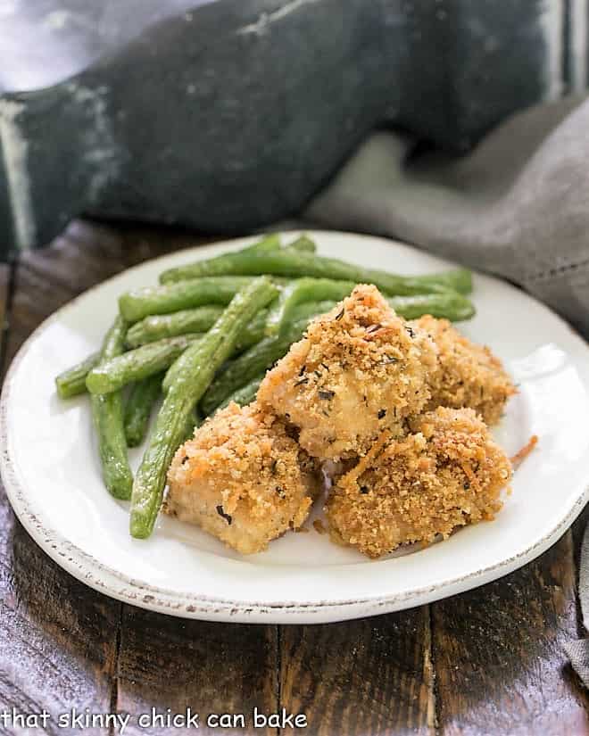 homemade chicken nuggets on a white plate with roasted green beans