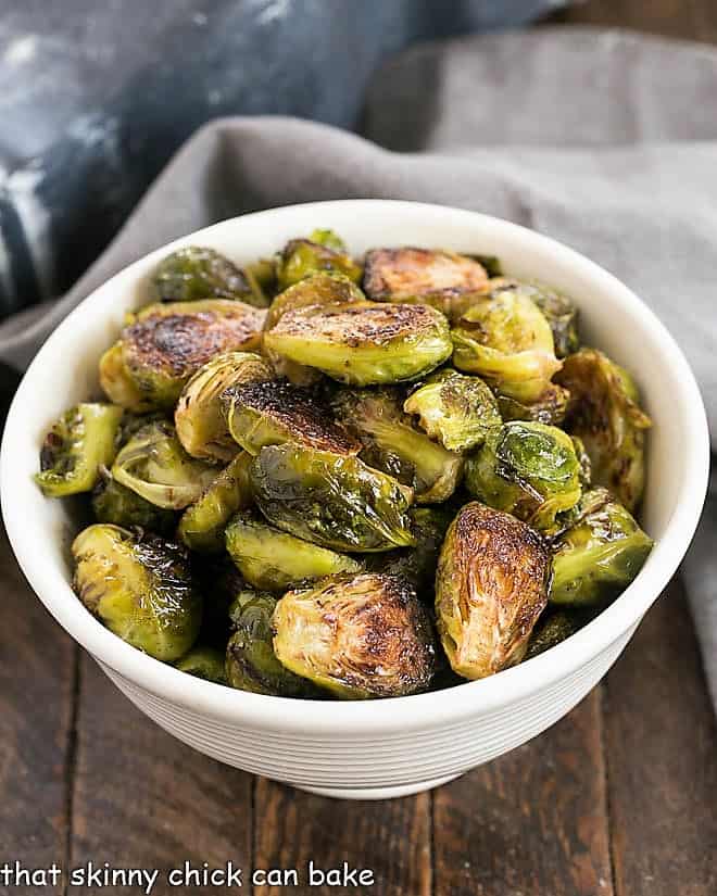 Overhead view of honey balsamic brussels sprouts in a white bowl.