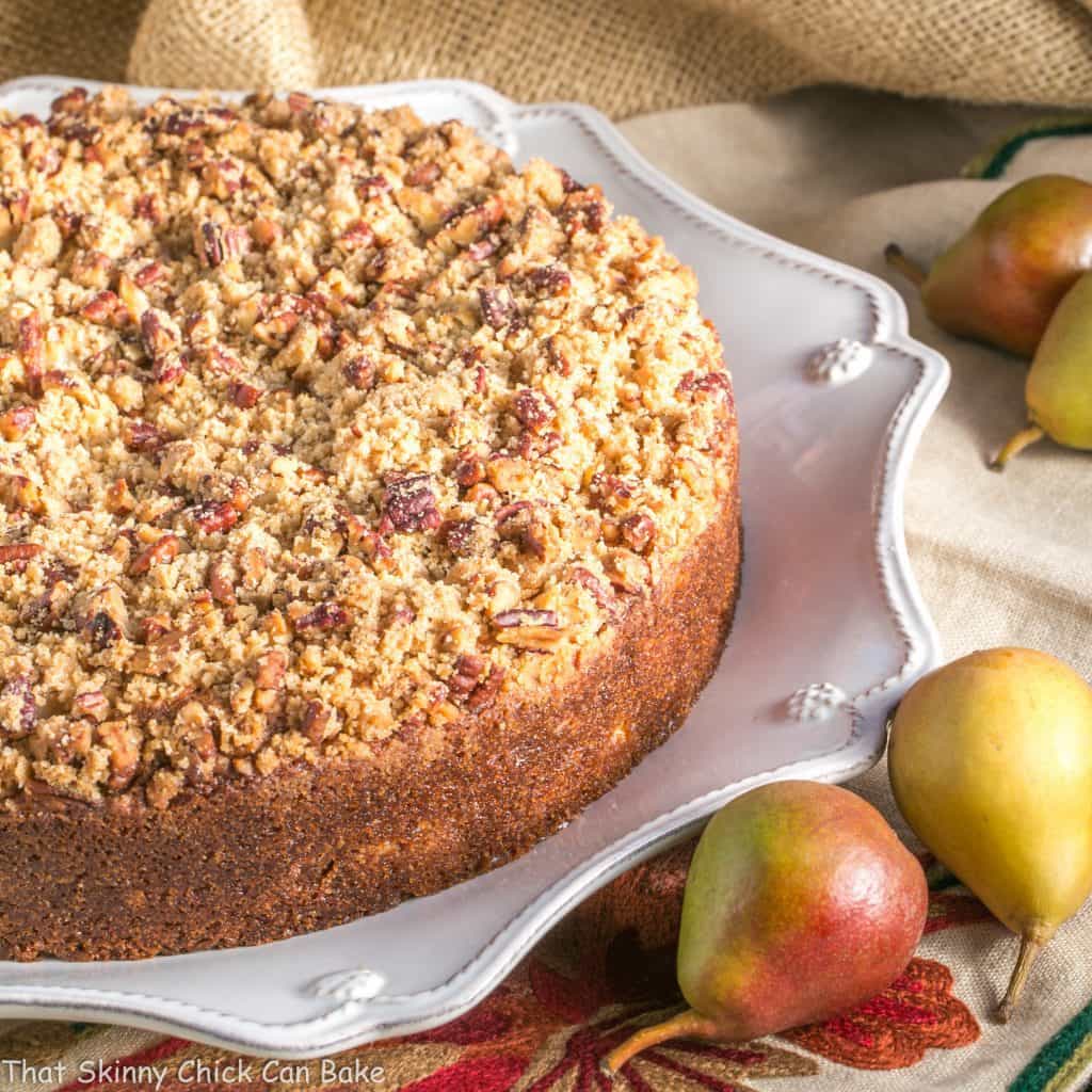 Pear Streusel Coffee Cake on a white platter with fresh pears