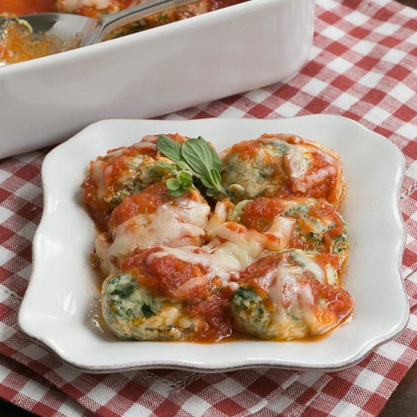 Storzapretis AKA Spinach Gnocchi - topped with marinara for a tasty meal! Storzapretis AKA Spinach Gnocchi on a white plate with marinara and cheese