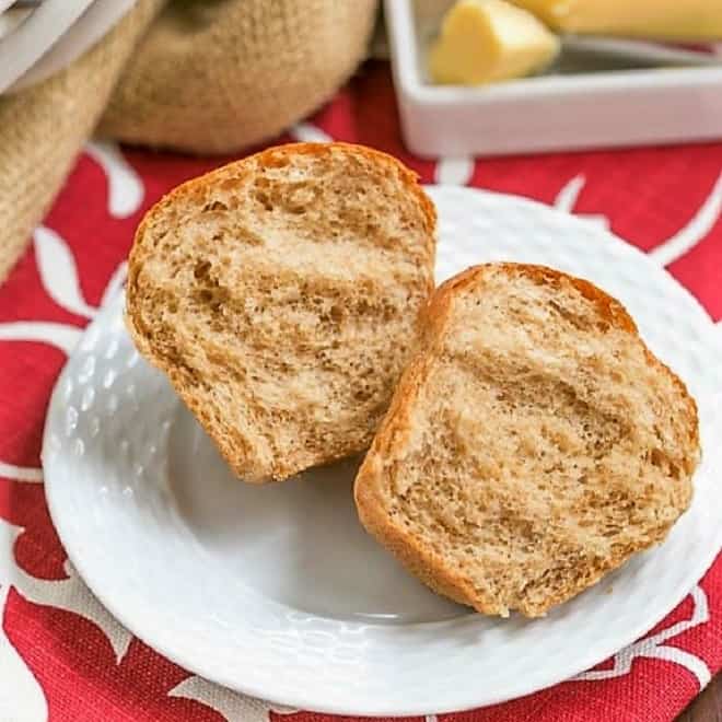  A Whole Wheat Dinner Roll on a white plate, split open 