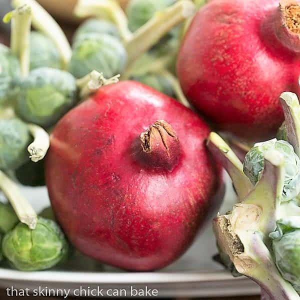 Pomegranates and Brussels sprouts on a sheet pan.