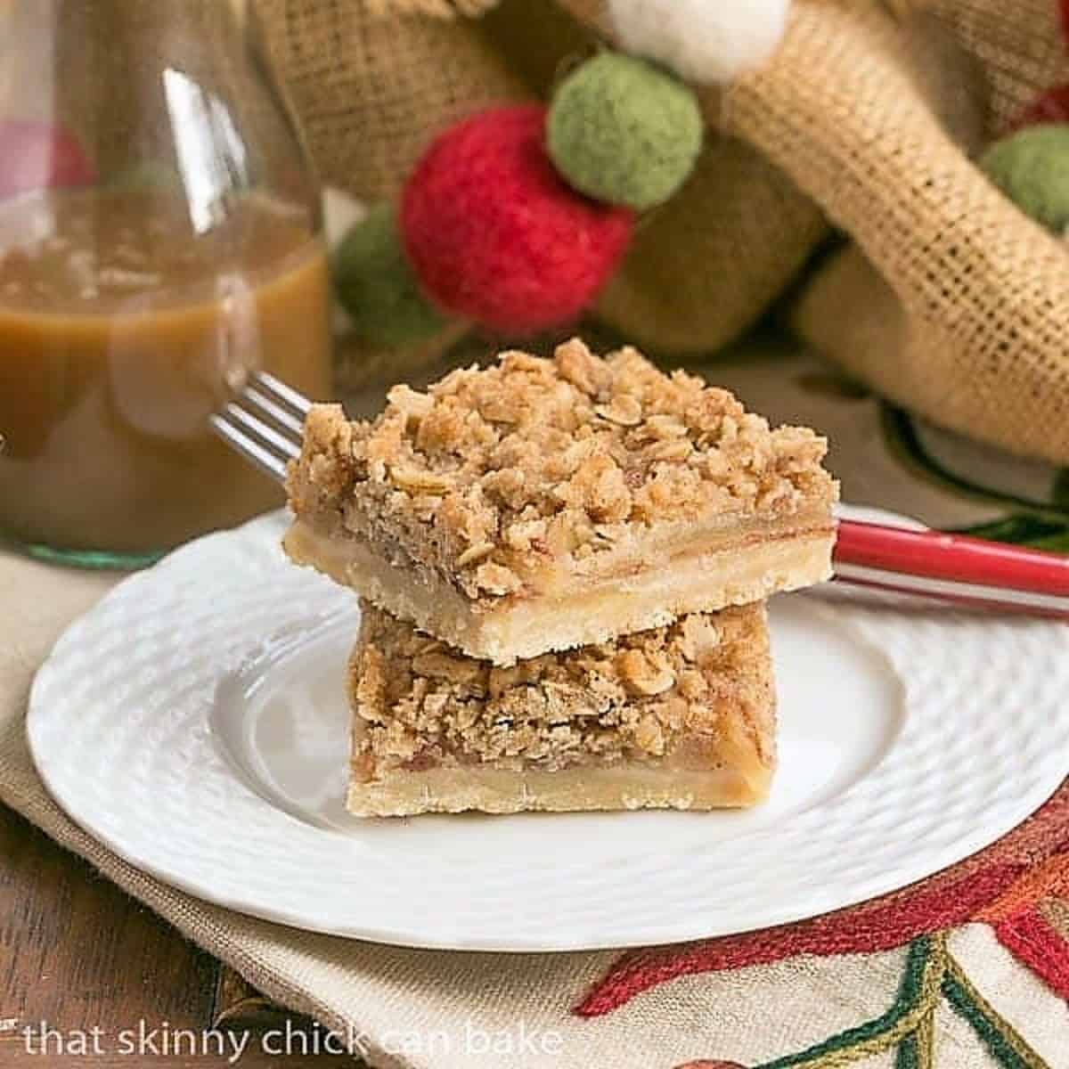 Apple Streusel Bars stacked on a white dessert plate.