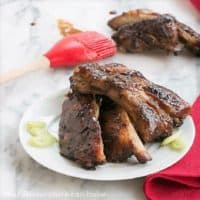Asian Baby Back Ribs on a white plate with a red basting brush