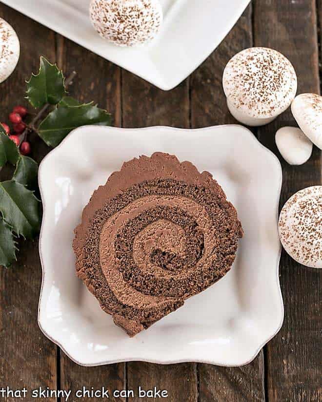 Christmas Yule Log Cake Roll slice from above with meringue mushrooms.