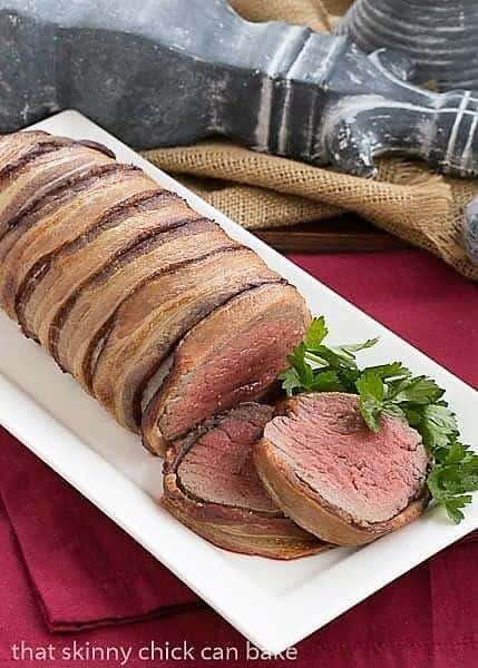 Beef Tenderloin with Gorgonzola Sauce wrapped in bacon on a white platter