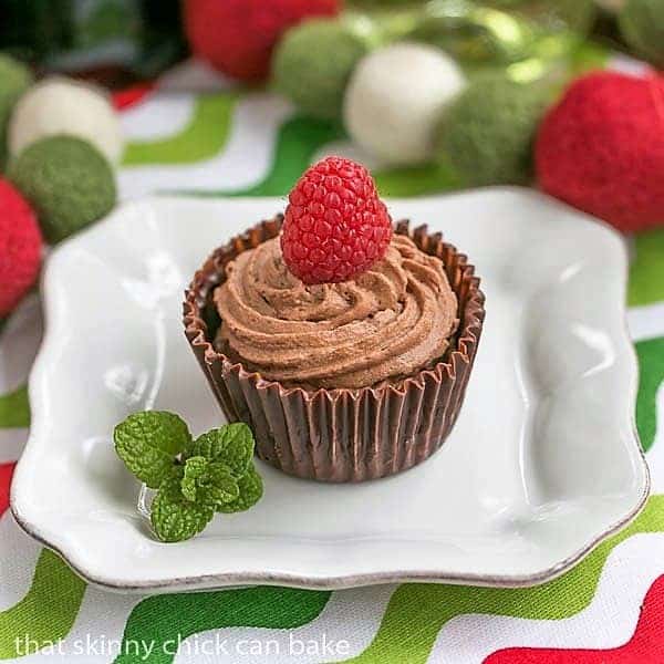 Chocolate Mousse Cups on a small white plate with a raspberry and mint