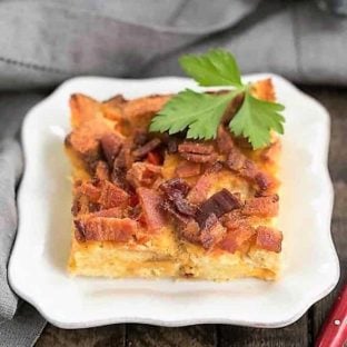 Bacon and egg strata slice on a small white plate