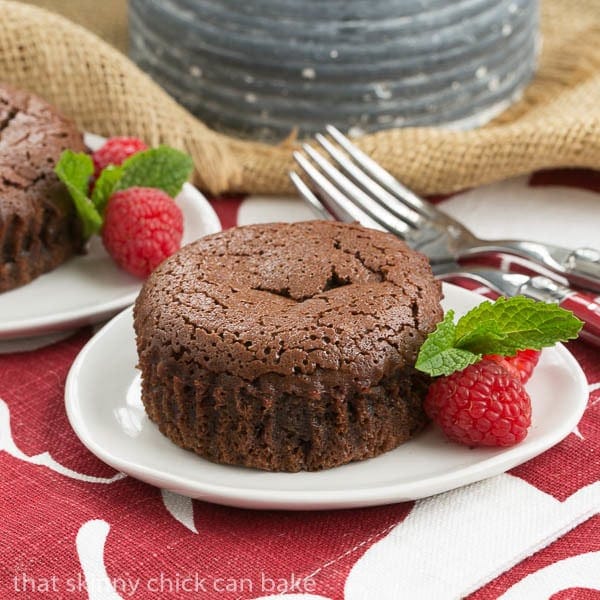 Chocolate Lava Cakes on a white plate with raspberries and mint.