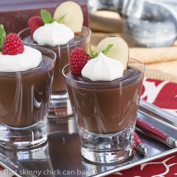 Double Chocolate Pudding in highball glasses topped with cream, berries and mint.